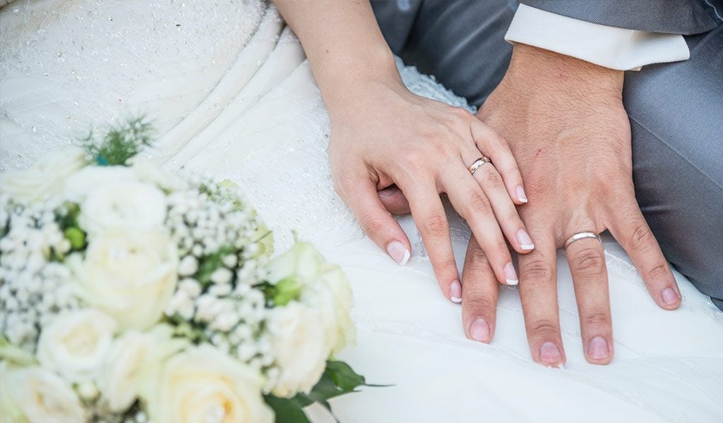 Ehepaar trägt Ringe an linker Hand