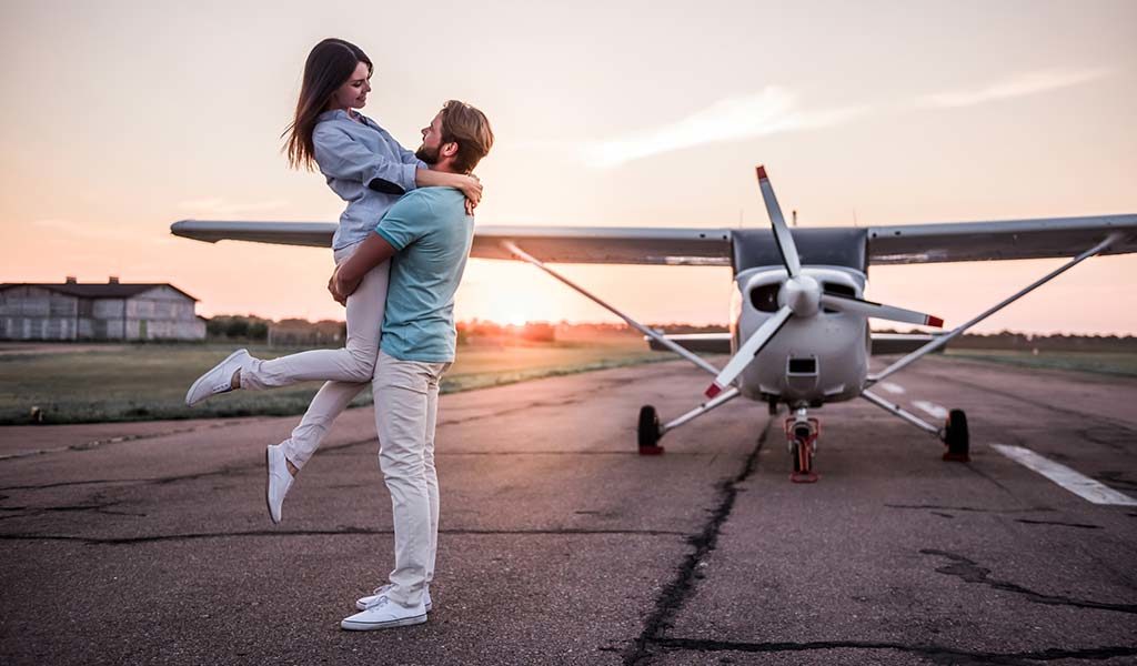 couple in front of plane